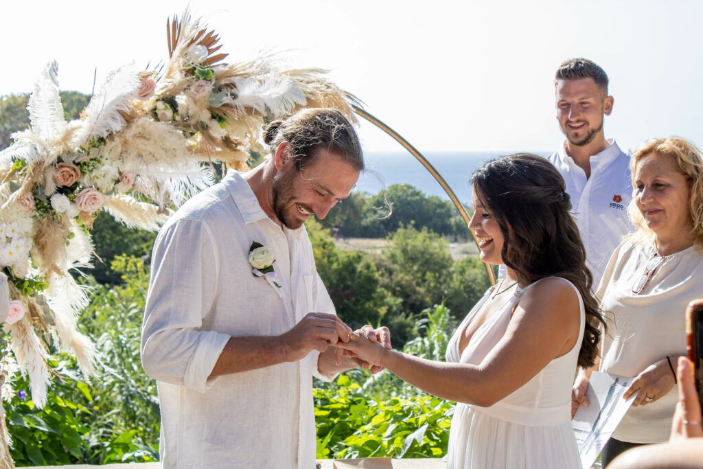 married couple exchanging wedding rings boho arch decorations rental hire Lemba Vrisi Paphos