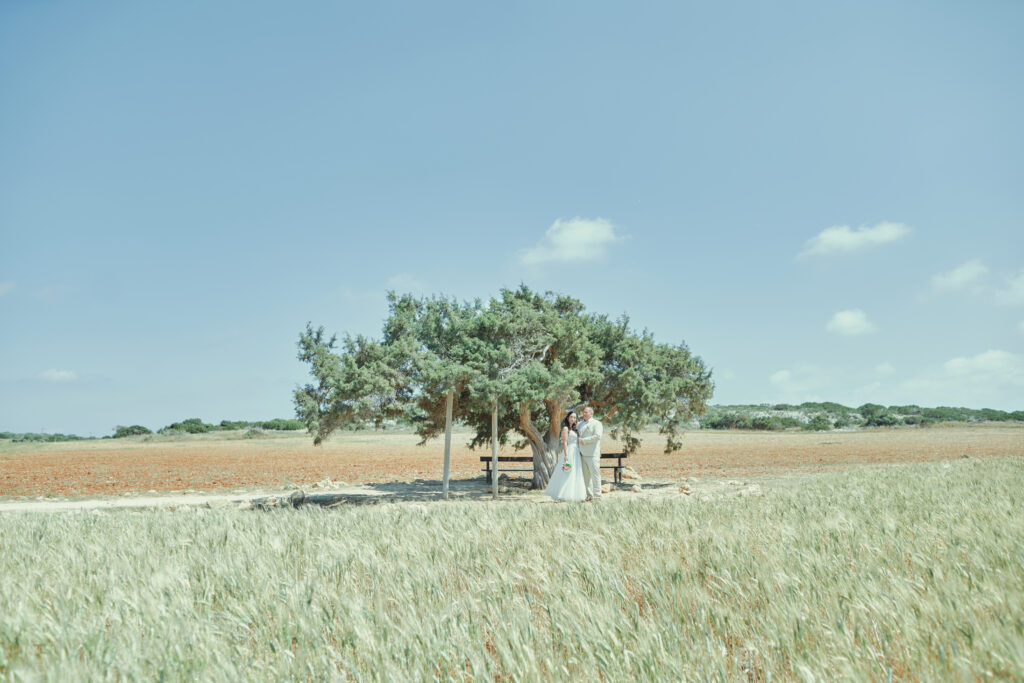 romantic wedding photoshoot at Tree of Lovers near Cape Greco Cyprus. Beautiful May scenery when fields and growing and everything is green