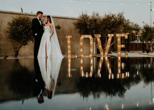 bride and groom having wedding photoshoot at The Legacy Venue in Cyprus Near Ayia Napa and Protaras including the LED Love sign as part of decoration hire