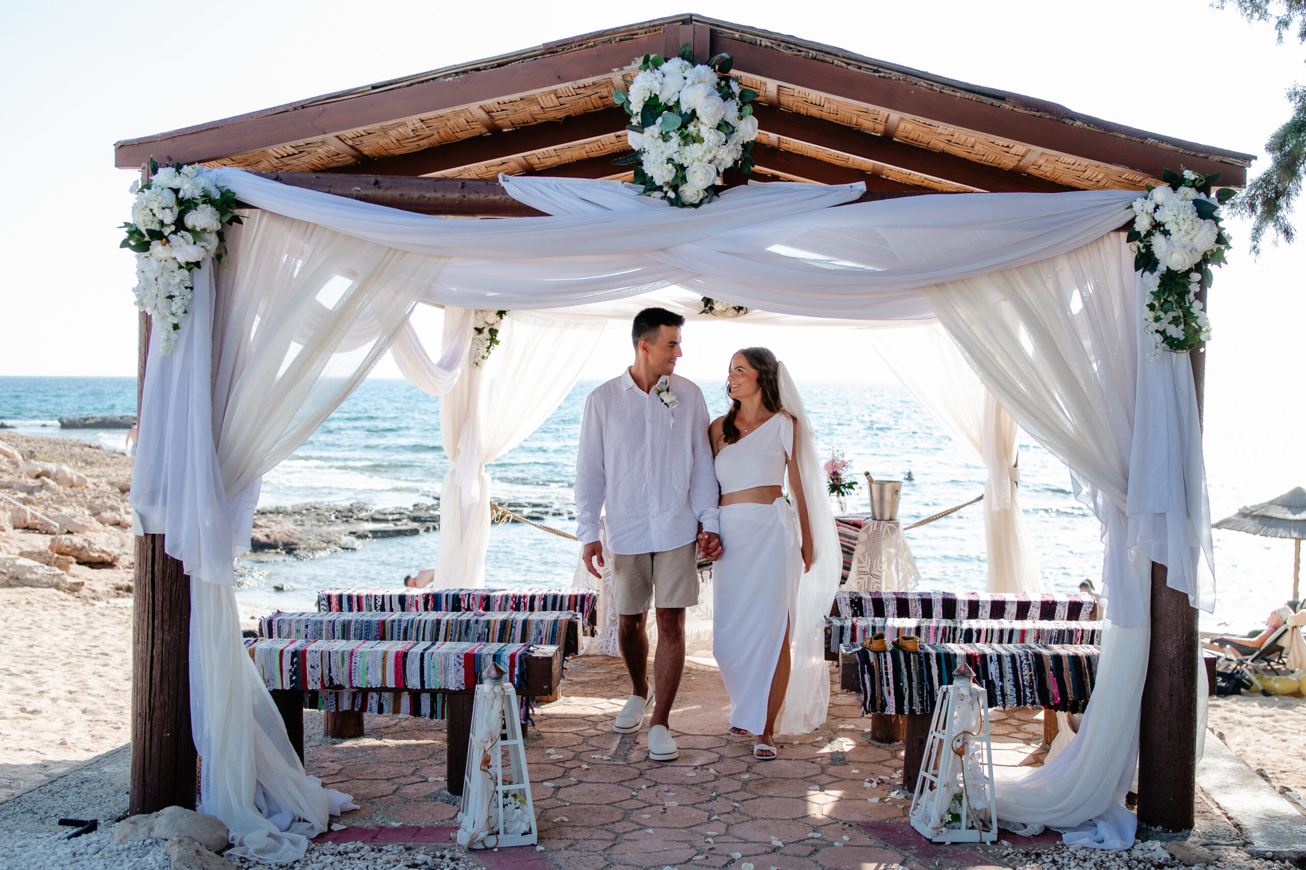 Bride and groom exchanging vows under a wooden gazebo at Ammos Kampouri beach, Ayia Napa.
