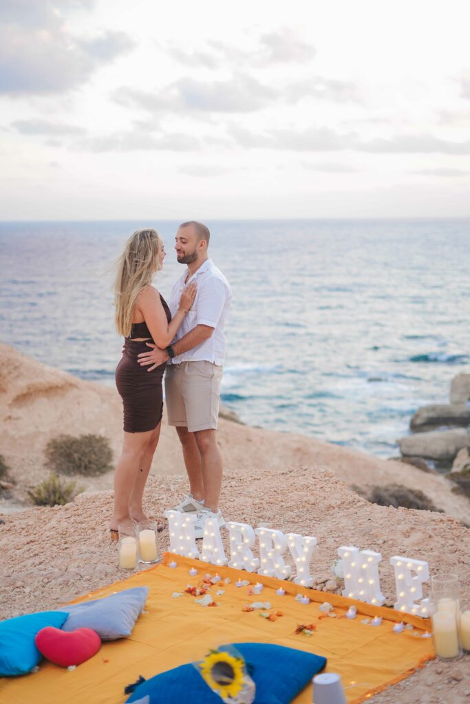 couple standing in front of marry me sign in Paphos Cyprus