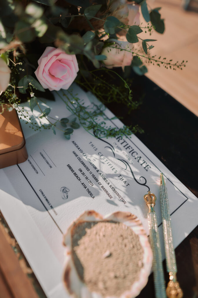 detailed photo of the marriage certificate including sea shell for the wedding rings and fresh roses table decoration