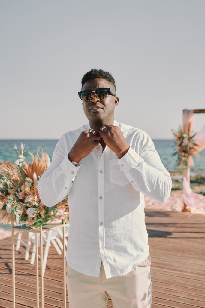 handsome groom enjoying his professional photoshoot near the sea in Ayia Napa with beautiful boho decorations