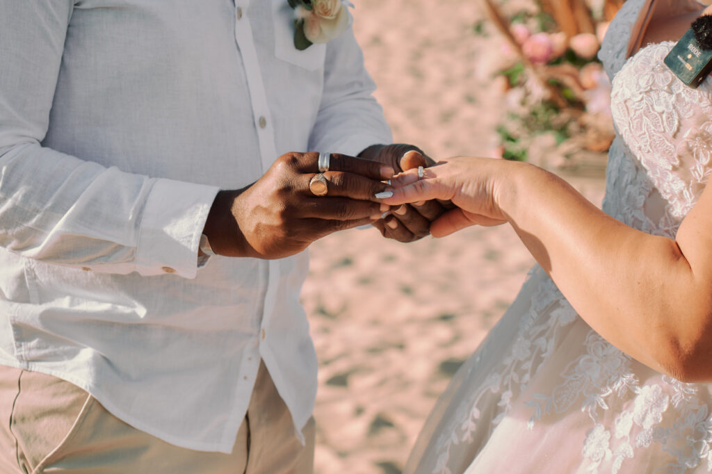 bride and groom exchanging the rings during their beach wedding ceremony