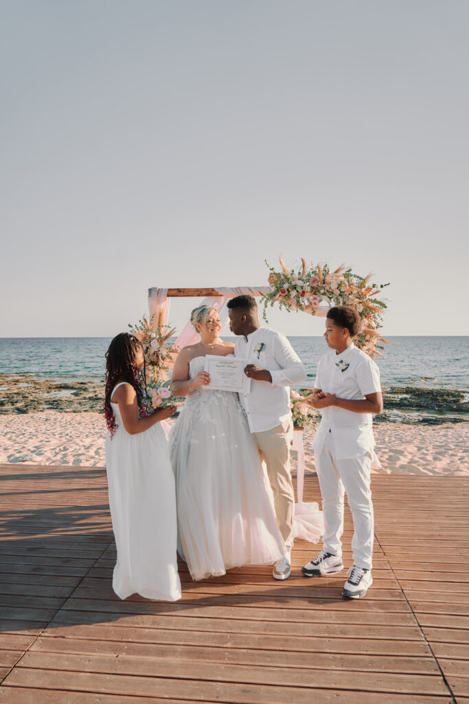 just married couple holding their marriage certificate at their beach wedding in Cyprus