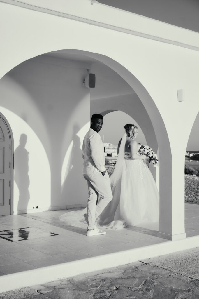 black and white wedding photograph of bride and groom outside of Ayia Thekla chapel in Cyprus