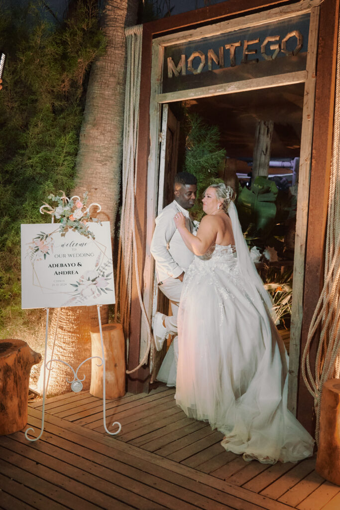 romantic bride and groom standing next to their wedding welcome sign at Montego bar in Pernera Cyprus