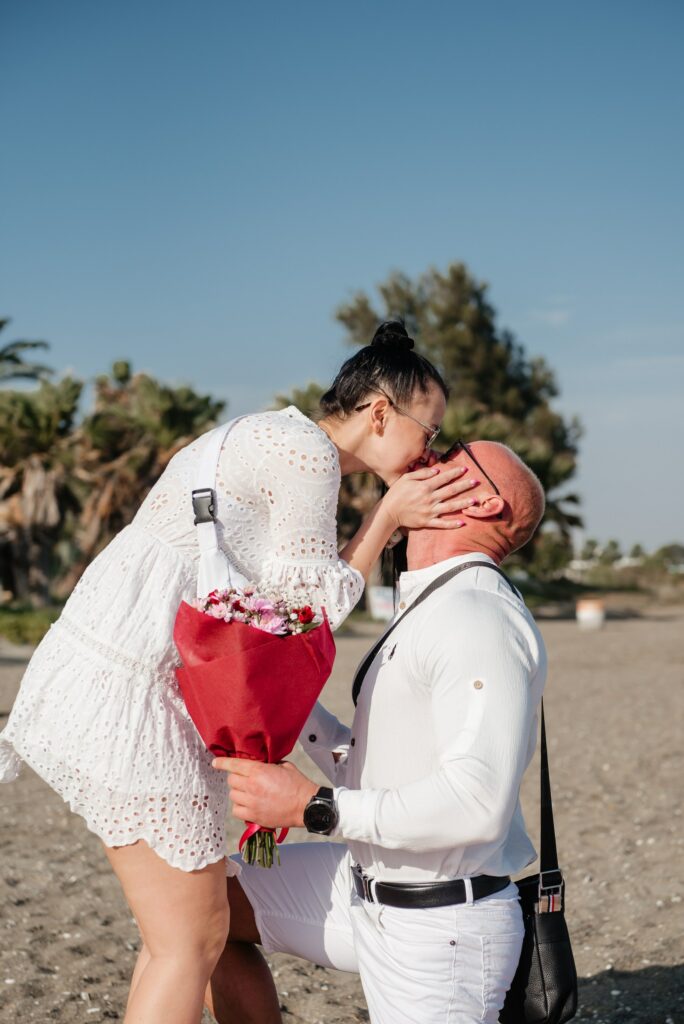 a guy got down on his knee to propose to his girlfriend during the romantic beach proposal in Larnaca Cyprus