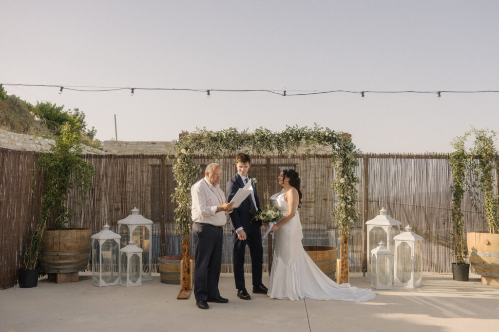 wedding ceremony at Dafermou winery with a rustic wooden arch