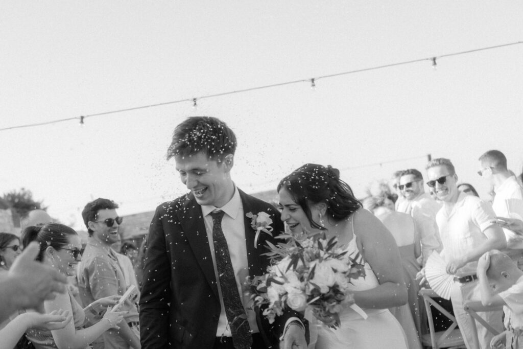 black and white photography of bride and groom laughing after the wedding ceremony in rustic winery in Cyprus