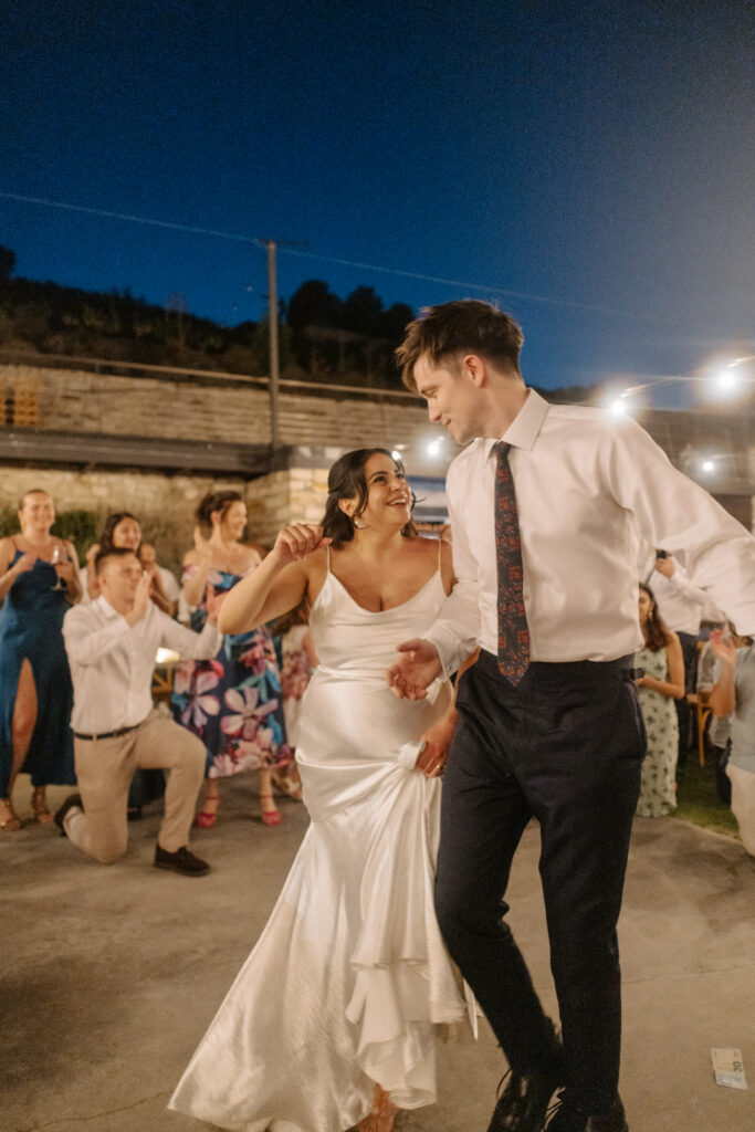 bride and groom dancing traditional Greek dance during their romantic wedding at the rustic venue in Cyprus