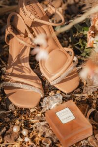 detailed wedding photography focusing on a bridal beige shoes and a perfume