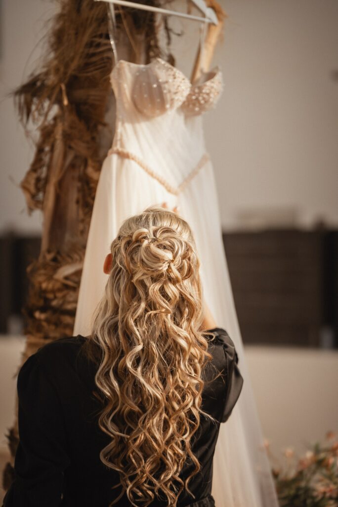 Bride with a luxury bridal hairstyle looking at her wedding dress during a Cyprus wedding