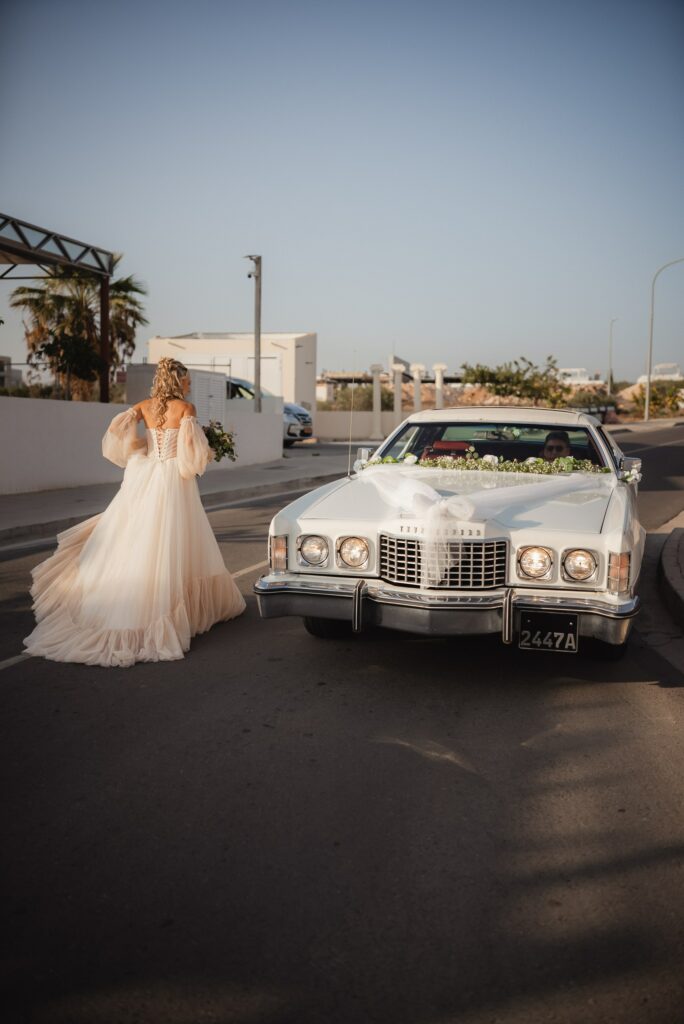 bride next to the vintage car going to her wedding ceremony in Ayia Napa Cyprus