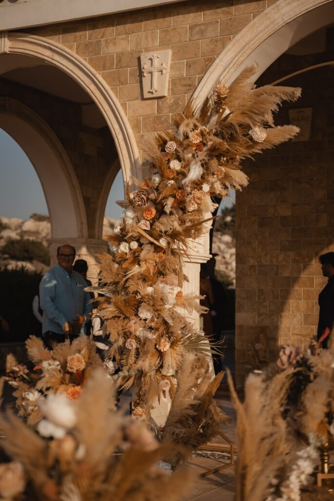 Boho wedding round arch decorated with pampas grass at a church in Cyprus, styled with elegant floral and décor rentals for a romantic ceremony.