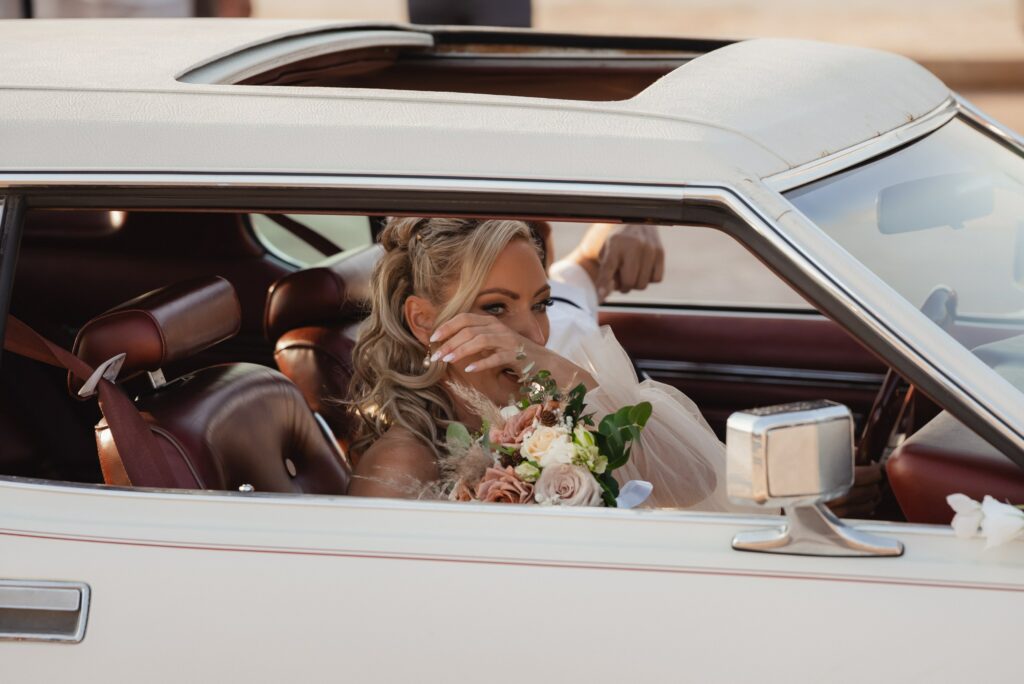 bride getting emotional while getting out of the vintage car during her wedding in Cyprus