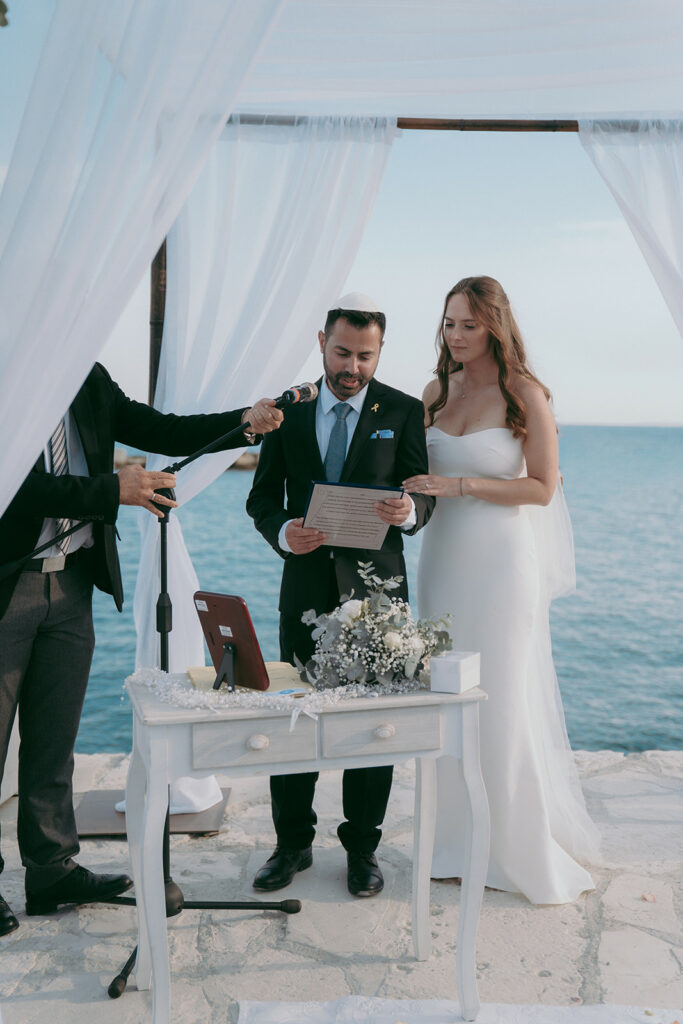 Bride and groom exchanging wedding vows under a Jewish chuppah on the pier at Four Seasons Hotel, Limassol, Cyprus