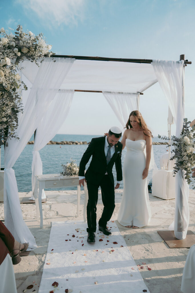 Groom performs the glass-breaking ceremony under the chuppah at a wedding in Cyprus.