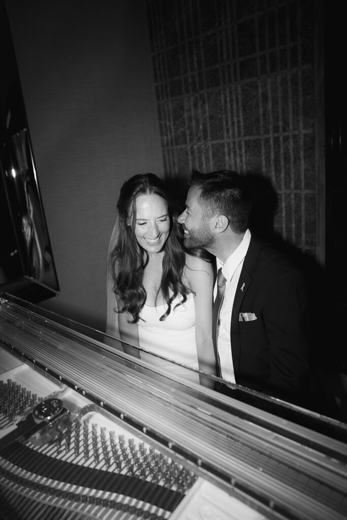 Black and white portrait of bride and groom playing piano at Four Season Hotel in Limassol, Cyprus