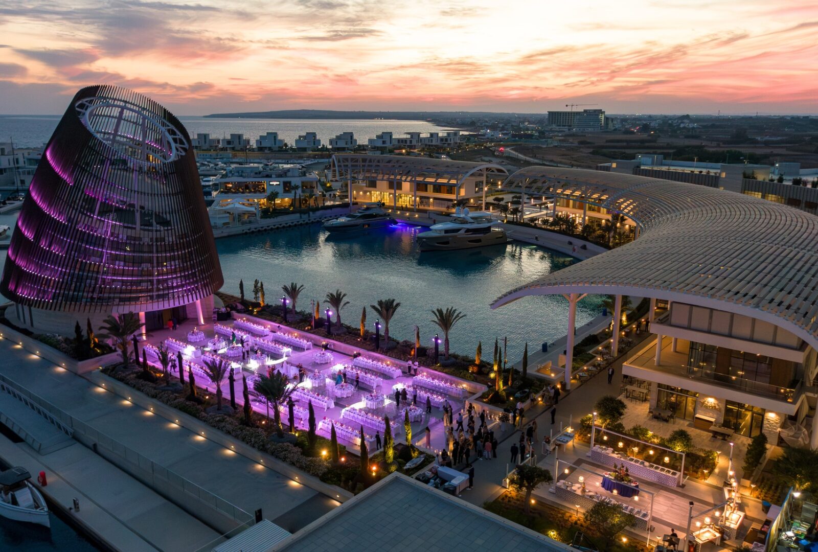 Luxury outdoor glamorous evening wedding banquet at the Ayia Napa Marina Event Center, showing the iconic conical architecture and harbor views in Cyprus.