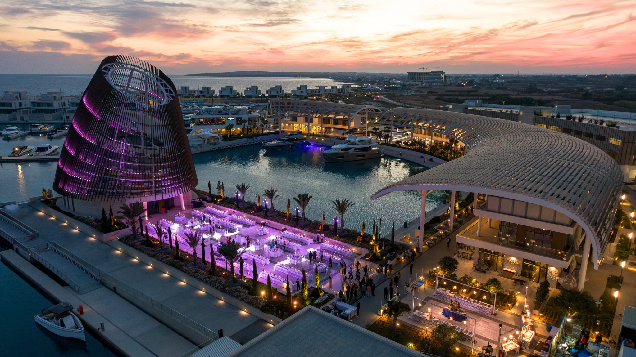 Luxury outdoor glamorous evening wedding banquet at the Ayia Napa Marina Event Center, showing the iconic conical architecture and harbor views in Cyprus.