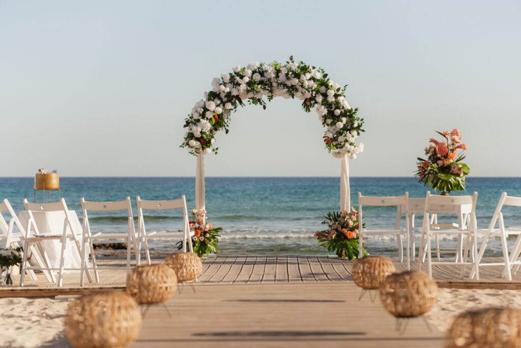 Symbolic beach wedding ceremony setup in Cyprus, Europe with elegant floral wedding arch, white chairs, and romantic seaside wedding venue in Ayia Napa and Protaras, perfect destination wedding location by the Mediterranean Sea.