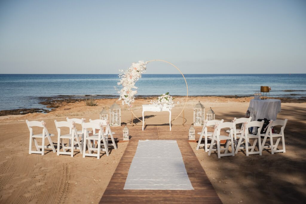 luxury gold circle wedding arch with white florals, rustic ceremony table and white carpet at Ayia Triada beach wedding venue